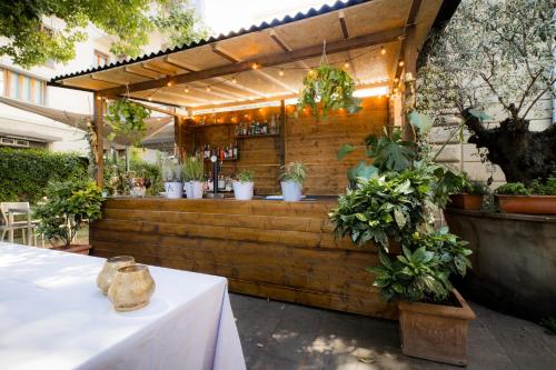 a bar with potted plants on a wooden wall at Allegroitalia San Gallo Firenze in Florence