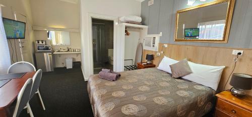 a hotel room with a bed and a desk and a kitchen at Blue Lake Motel in Mount Gambier