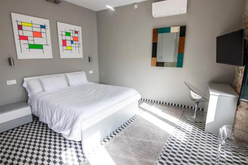 a bedroom with a white bed and a tv at Hotel Rural La Casa de Carlota in Montánchez