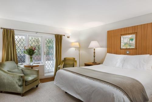 - une chambre avec un lit, une chaise et une fenêtre dans l'établissement Woodford Bridge Country Club, à Milton Damerel
