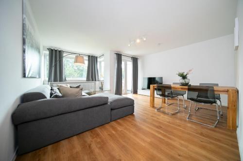 uma sala de estar com um sofá e uma mesa em Favorite Stays - Suite And More - Neuss em Neuss