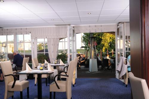 a dining room with tables and chairs and people sitting at Hotel Boddenhus Garni in Zingst