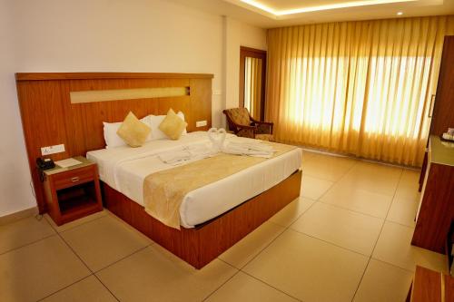 a bedroom with a large bed in a hotel room at The Lake View Munnar in Munnar