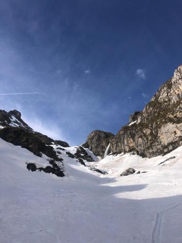 a snow covered mountain with rocks and a blue sky at Casa Rural Basiver - Habitación Pico San Carlos in Armaño