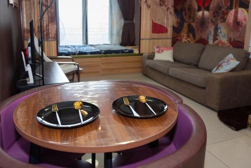a living room with a table with two plates on it at Kisetsu no ie, KLCC Kuala Lumpur in Kuala Lumpur