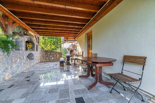 un tavolo e sedie su un patio con parete in pietra di Vineyard Cottage Pyramid - Happy Rentals a Dobrnič