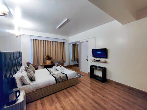 a hotel room with a bed and a tv at Namdul Boutique in Gangtok