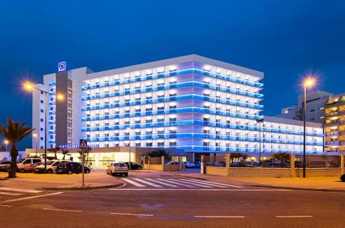 un grande edificio blu con auto parcheggiate in un parcheggio di Hotel Best Sabinal a Roquetas de Mar