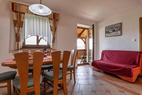 uma sala de jantar com uma mesa e cadeiras e um sofá em Vineyard Cottage Ucman - Happy Rentals em Otocec