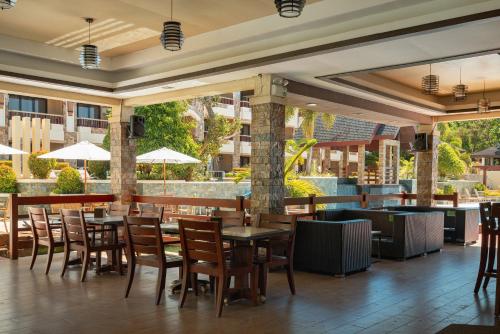 restauracja ze stołami i krzesłami oraz bar w obiekcie Coron Westown Resort w mieście Coron