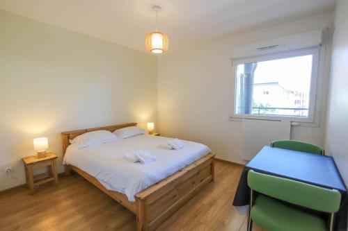 une chambre avec un lit, un bureau et une fenêtre dans l'établissement Le Discret T2 aux portes de la vieille ville, à Annecy