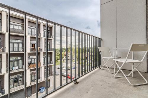 a balcony with chairs and a view of a city at RentPlanet - Apartamenty Zarembowicza in Wrocław