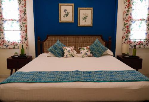 a bedroom with a bed with blue walls and windows at Chanoud House in Jodhpur