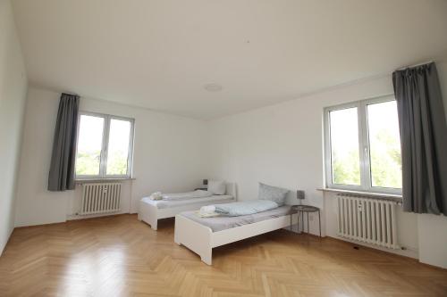 a white room with a couch and two windows at MOWO Marshall 8 - Apartmenthaus Kitzingen - großzügige Wohnungen für je 6 Personen mit Balkon in Kitzingen
