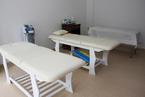 two hospital beds in a room with a table at Hotel President in Baile Felix