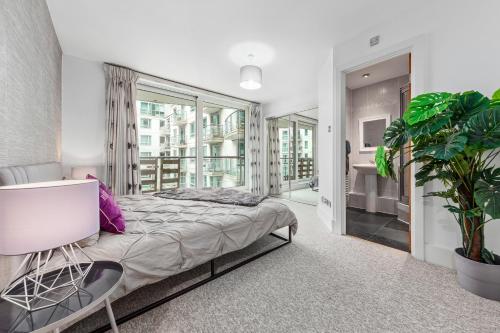 a bedroom with a bed and a plant at St, George Wharf Vauxhall Bridge large 2Bedrooms apartment with River View panoramic balcony in London