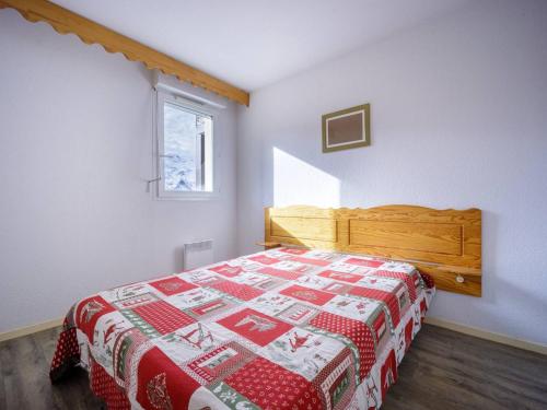 a bedroom with a bed with a red and white quilt at Appartement Peyragudes, 2 pièces, 6 personnes - FR-1-695-9 in Germ