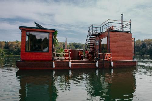 uma pequena casa numa barcaça na água em AQUACHILL houseboat & wellness em Liptovský Trnovec