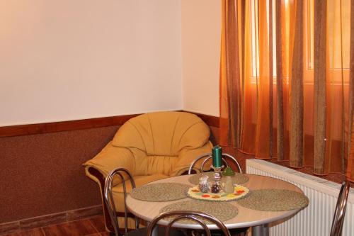 einen Tisch und einen Stuhl mit einem Tisch, einem Tisch und einem Vorsitzenden in der Unterkunft Casa Dănuț in Reşiţa