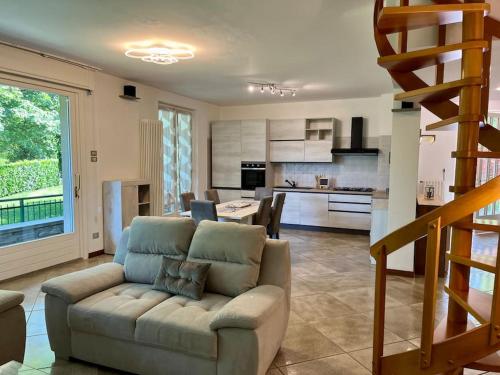 uma sala de estar com um sofá e uma cozinha em Villa Merone - Pusiano Lake em Merone