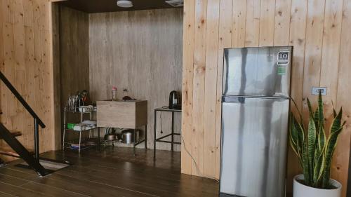 a stainless steel refrigerator in a room with wooden walls at Bách Xanh House Venuestay in Vĩnh Phúc