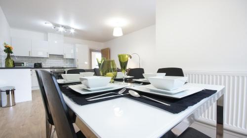 a kitchen with a table and chairs and a refrigerator at Andora Apartments in London