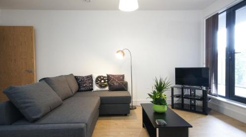a living room with a couch and a tv at Andora Apartments in London