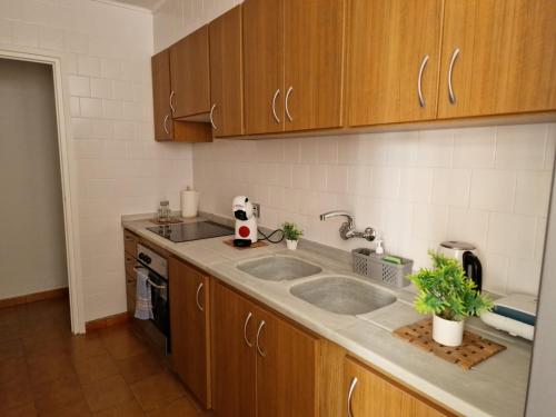 Sabor a esperanza في كولرا: مطبخ مع مغسلتين ودواليب خشبية