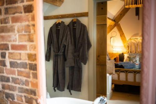 a room with a door with coats hanging on a wall at The Cart House - Beautiful Contemporary Barn - Hot Tub in Bridgnorth