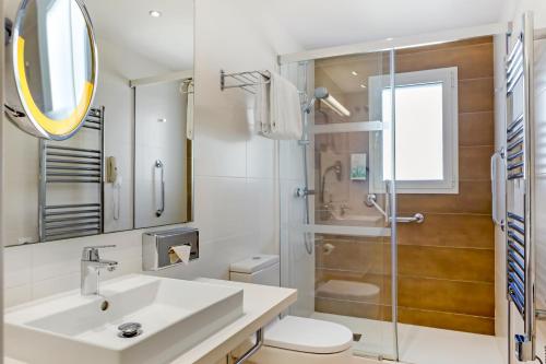 bagno con lavandino e doccia di White Sands Beach Club ad Arenal d'en Castell