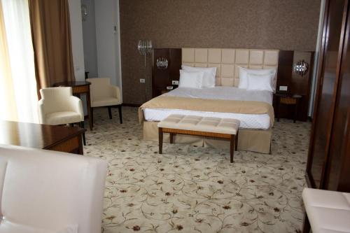a hotel room with a bed and a table and chairs at Hotel President in Baile Felix