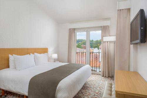 a hotel room with a bed and a balcony at Le Club Mougins in Mougins