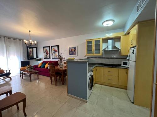 uma cozinha e sala de estar com um sofá e uma mesa em Apartamentos Turisticos Juanita "Ope" em Archena