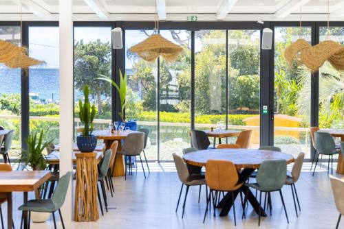 un restaurant avec des tables et des chaises et de grandes fenêtres dans l'établissement Luxotel Cannes, à Cannes