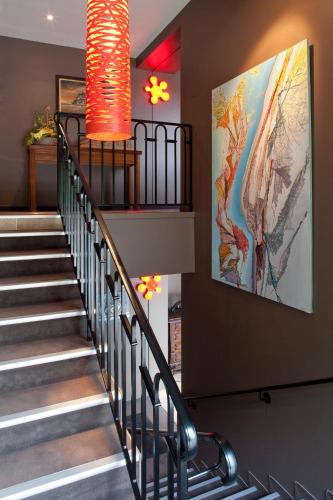 a staircase in a building with a painting on the wall at Logis La Source Bleue in Gudmont