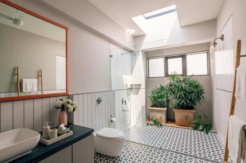 e bagno con doccia, servizi igienici e piante. di LohonoStays Villa Trisara a Lonavala