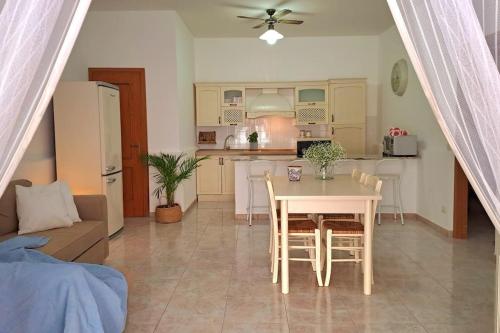 a kitchen and dining room with a table and chairs at Ambra in Stazzo