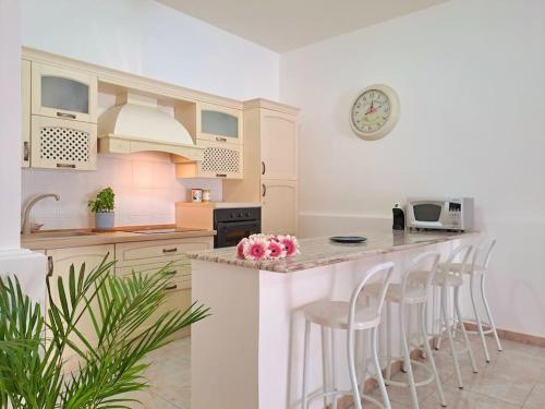 a kitchen with a counter and stools in a room at Ambra in Stazzo