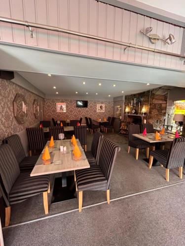 a restaurant with tables and chairs in a room at St Duthus Hotel Apartment in Tain