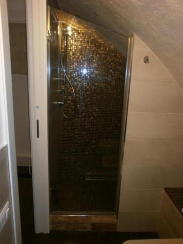 a shower in a bathroom with a tile wall at Le 2 Gravine nei Sassi in Matera