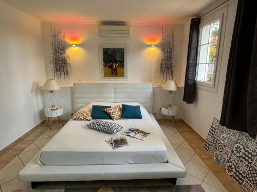 une chambre avec un grand lit blanc avec deux lampes dans l'établissement Maison en pleine nature -Domaine des mille pierres, à Laudun-l'Ardoise