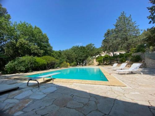 une piscine avec deux chaises et une table dans l'établissement Maison en pleine nature -Domaine des mille pierres, à Laudun-l'Ardoise