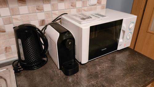 a microwave sitting on a counter next to a toaster oven at Bohemica Apartments in Děčín