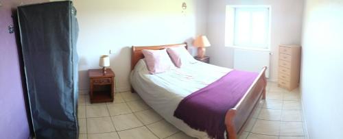 a bedroom with a bed with a purple blanket at Taborda familly 