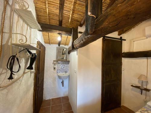 baño con lavabo y puerta de madera en Sa domu de don Ninnu bed breakfast Spa en Gesturi