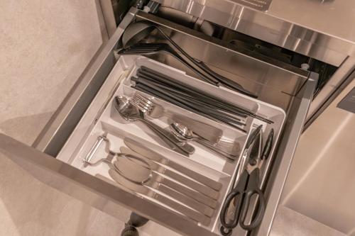 an open refrigerator drawer with utensils in it at Relax Hotel Takayama Station in Takayama
