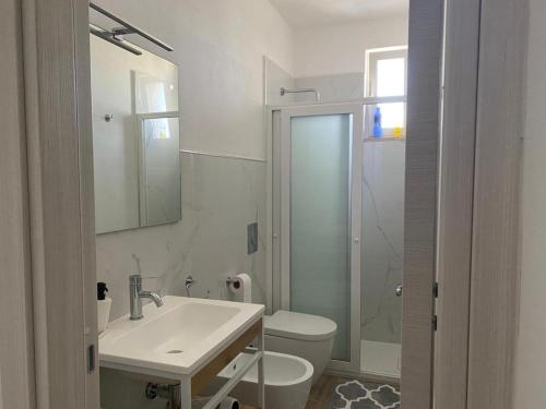 uma casa de banho branca com um lavatório e um WC em La maison du mar em Bari