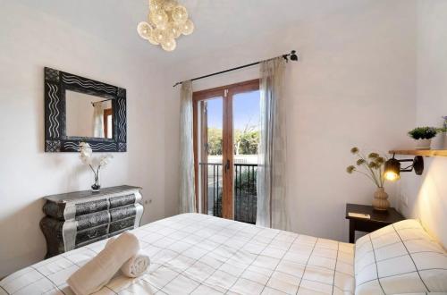 um quarto com uma cama, um espelho e uma janela em Carrajolilla Sancti petri em Chiclana de la Frontera