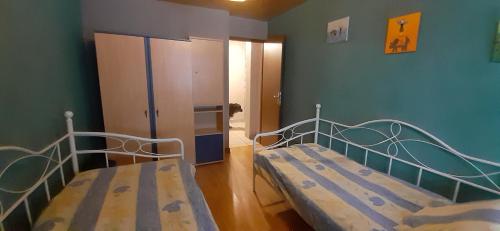 a bedroom with two beds and a cabinet in it at Gites de le musre in Laveline