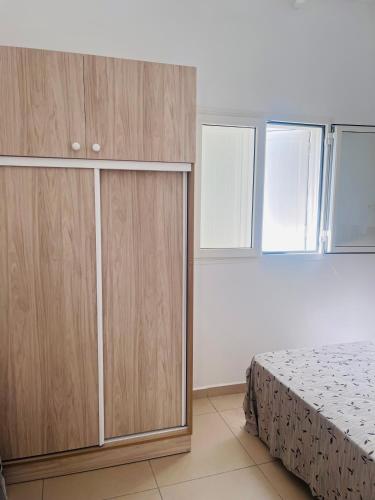 una camera da letto con un letto e armadi in legno di Ruddy’s house a Le Gosier